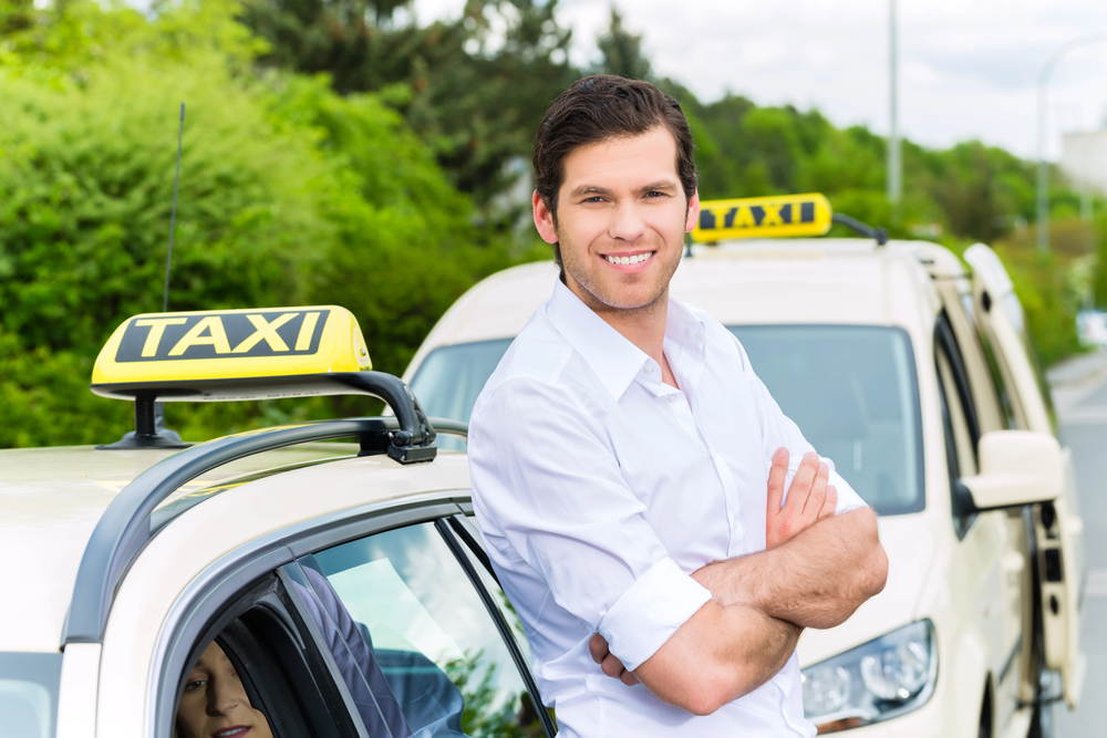 hombre taxista frente a su vehiculo sonriendo